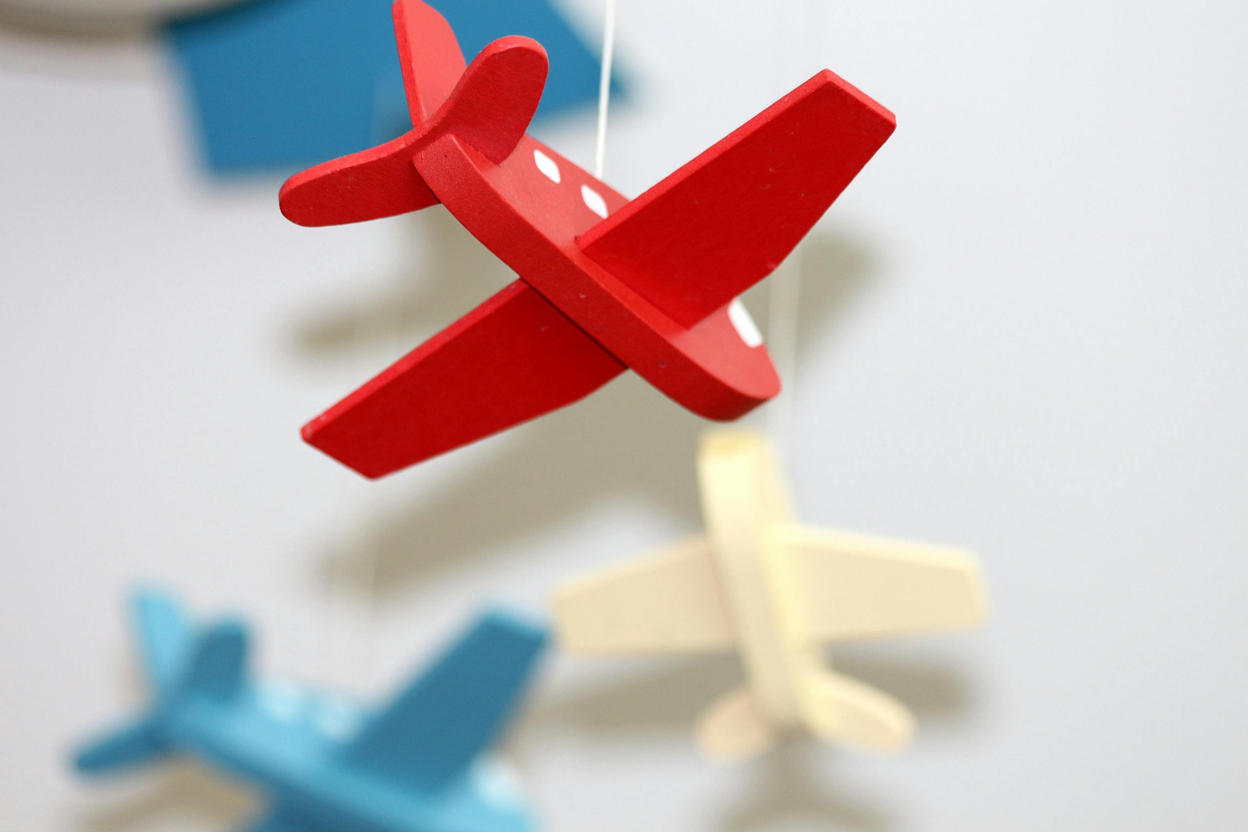 A close-up of colorful wooden airplane toys in a mobile, perfect for nursery décor.